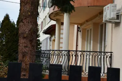 a fence in front of a house with a tree at Apartament DeLuxe 1 in Oświęcim