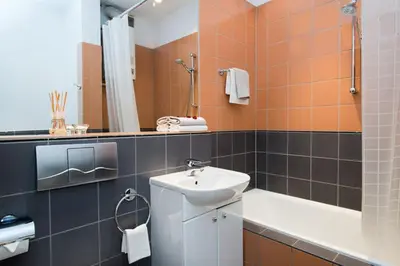 a bathroom with a sink and a toilet and a tub at Apartament Amaryllis in Kraków