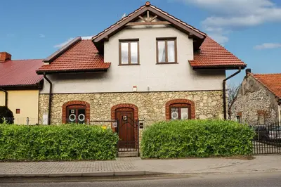 a brick house with a red roof at Pokoje w Starej Karczmie - by Upstairs in Liszki