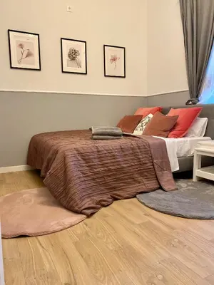 a bedroom with a bed with colorful pillows and a mirror at Pokoje w Starej Karczmie - by Upstairs in Liszki