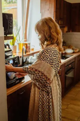 a woman in a kitchen preparing food in an oven at Zacisze in Morawica
