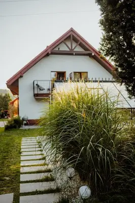 a white house with a balcony and some grass at Zacisze in Morawica