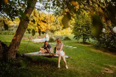two women sitting on a swing in a park at Zacisze in Morawica