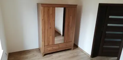 a wooden mirror in a corner of a room at Lion Apartment in Andrychów