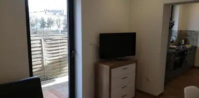 a room with a television on a dresser with a window at Lion Apartment in Andrychów