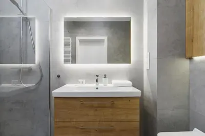a bathroom with a sink and a mirror and a shower at Apartments Supernova near Tauron Arena by Noclegi Renters in Kraków