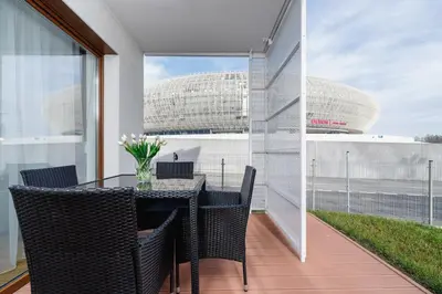 a dining room with a table and chairs on a balcony at Apartments Supernova near Tauron Arena by Noclegi Renters in Kraków