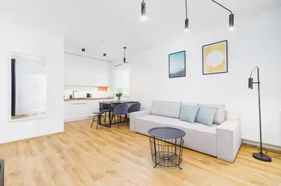 a living room with a white couch and a table at Apartments Supernova near Tauron Arena by Noclegi Renters in Kraków