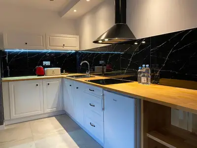 a kitchen with white cabinets and a black counter top at Apartamenty Centrum in Andrychów