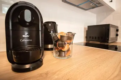 a black blender sitting on a counter with fruit in it at Tower Street Apartments in Kraków