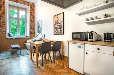 a kitchen and dining room with a table and chairs at Tower Street Apartments in Kraków