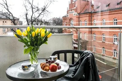 a table with a vase of flowers and fruit on a balcony at Otium Old Town Harmonica in Kraków