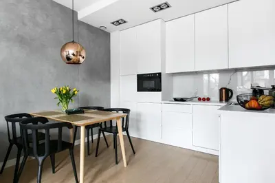 a kitchen with a wooden table and black chairs at Otium Old Town Harmonica in Kraków