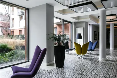a lobby with purple chairs and a potted plant at Otium Old Town Harmonica in Kraków