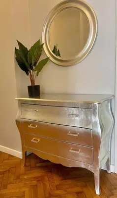 a dresser with a mirror and a potted plant at Floriańska Grand Apartment 2 in Kraków