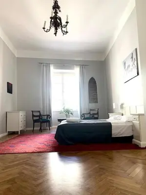 a bedroom with a large bed and a chandelier at Floriańska Grand Apartment 2 in Kraków