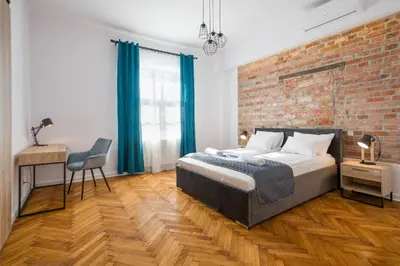 a bedroom with a large bed and a brick wall at Fancy Apartments with Lift and A/C in Kraków