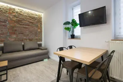 a living room with a table and a couch at Fancy Apartments with Lift and A/C in Kraków