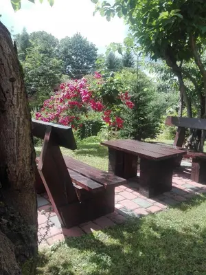a picnic table and bench in a park with pink flowers at Apartament Leszczynowa 7 blisko Zatora in Spytkowice