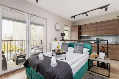 a bedroom with a large bed and a balcony at Apartments Old Town Rakowicka by Noclegi Renters in Kraków