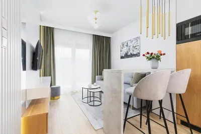 a kitchen and living room with a table and chairs at Apartments Old Town Rakowicka by Noclegi Renters in Kraków