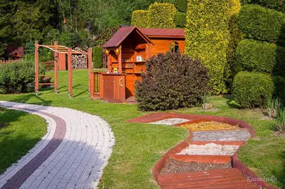a garden with a wooden house in the background at Kozinówka in Zawoja