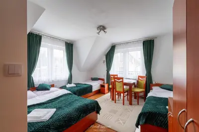 a bedroom with two beds and a table and chairs at Kozinówka in Zawoja