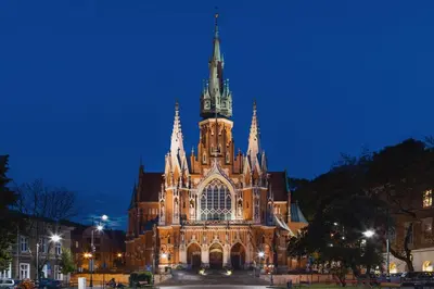 a large cathedral building with a clock tower at night at Modern Studio Węgierska Cracow by Noclegi Renters in Kraków