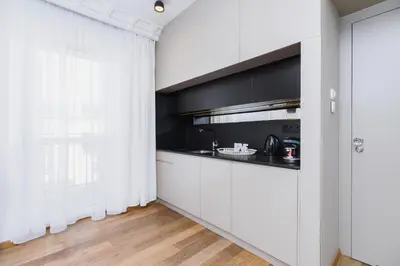 a kitchen with white cabinets and a window at Modern Studio Węgierska Cracow by Noclegi Renters in Kraków