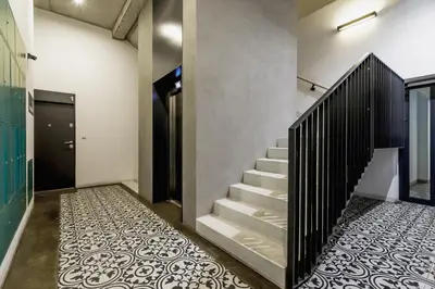 a staircase with a black railing and a tile floor at Modern Studio Węgierska Cracow by Noclegi Renters in Kraków