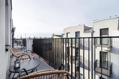 a balcony with two chairs and a table at Modern Studio Węgierska Cracow by Noclegi Renters in Kraków