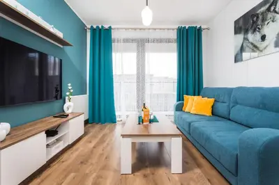a living room with a blue couch and a table at City of the Kings - Wolf Apartment in Kraków