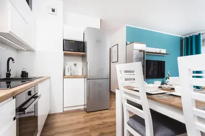 a kitchen with a table and a refrigerator at City of the Kings - Wolf Apartment in Kraków