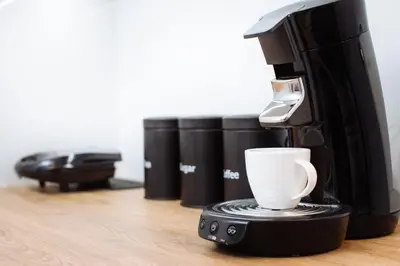 a coffee maker with a cup on a table at City of the Kings - Wolf Apartment in Kraków