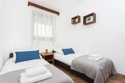a bedroom with two beds and a window at City of the Kings - Wolf Apartment in Kraków