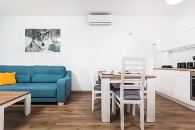 a living room with a blue couch and a table at City of the Kings - Wolf Apartment in Kraków