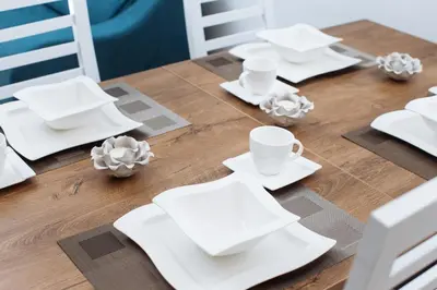 a wooden table with white plates and cups on it at City of the Kings - Wolf Apartment in Kraków