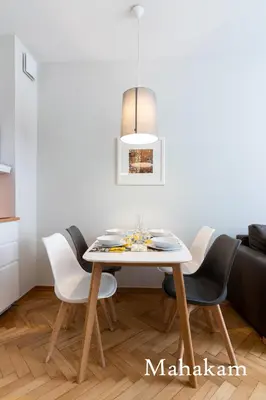a dining room with a white table and chairs at Brokilon House in Kraków