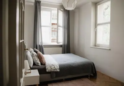 a small bedroom with a bed and a window at Brokilon House in Kraków