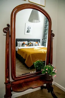 a bedroom with a large mirror on a bed at Brokilon House in Kraków