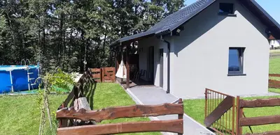 a small wooden house with a table and a chair at OSADA POD LASEM in Andrychów