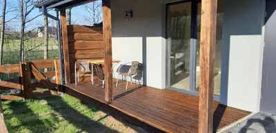 a small white house with a fence and a yard at OSADA POD LASEM in Andrychów