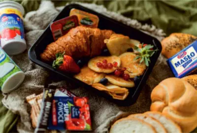 a tray of food with fruit and pastries and bread at Noclegi u Majki in Zator
