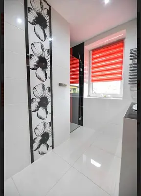 a bathroom with black and white flowers on the wall at Noclegi u Majki in Zator