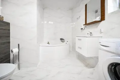 a white bathroom with a tub and a sink at Noclegi u Majki in Zator