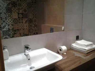a bathroom with a white sink and a mirror at Garden Corner in Kraków