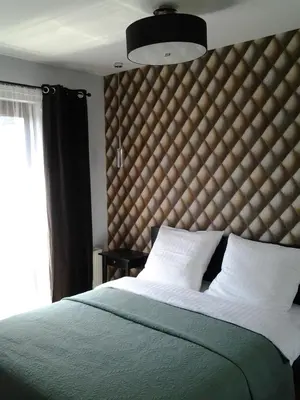 a bedroom with a large bed with a large headboard at Garden Corner in Kraków