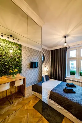 a hotel room with a bed and a desk and a room at Słowackiego Apartments in Kraków