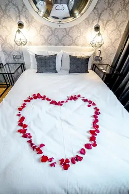a heart made out of red roses on a bed at Słowackiego Apartments in Kraków