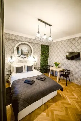 a bedroom with a large bed and a table at Słowackiego Apartments in Kraków